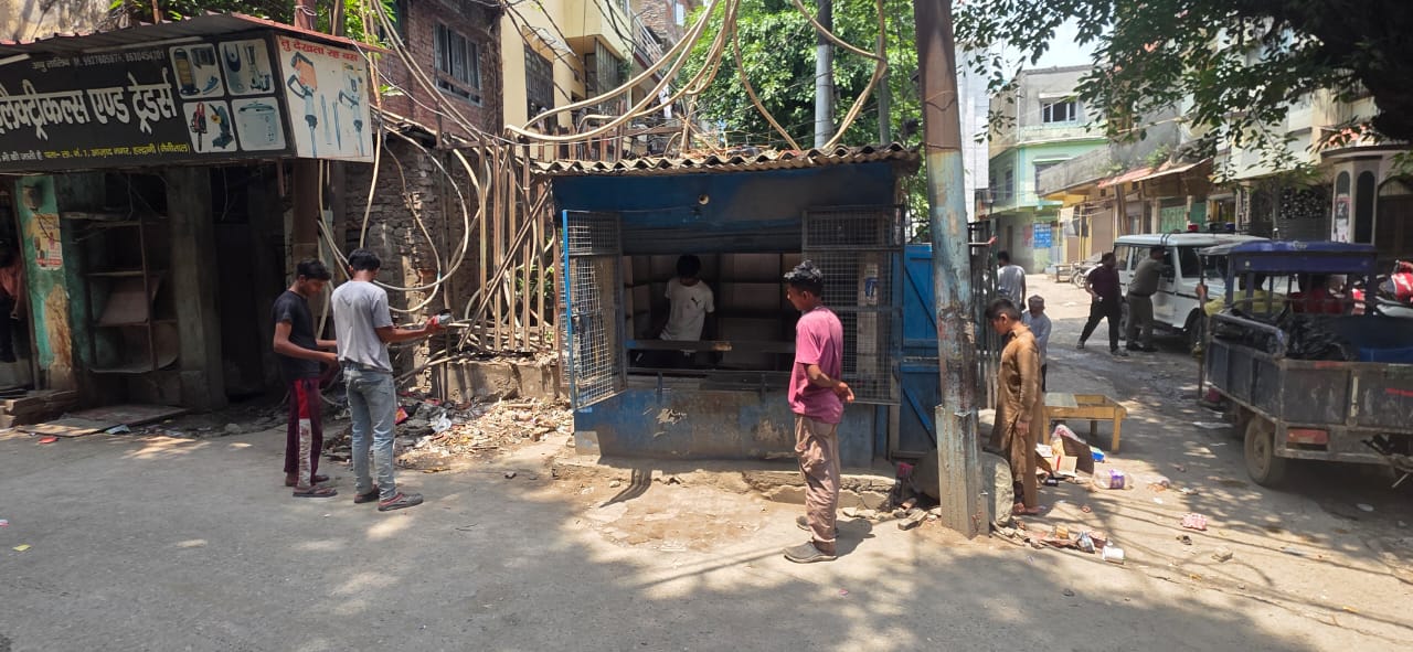 बनभूलपुरा में बिलाली मस्जिद के पास ट्रांसफार्मर से के आगे बनी पान की दुकान हटाते लोग।
