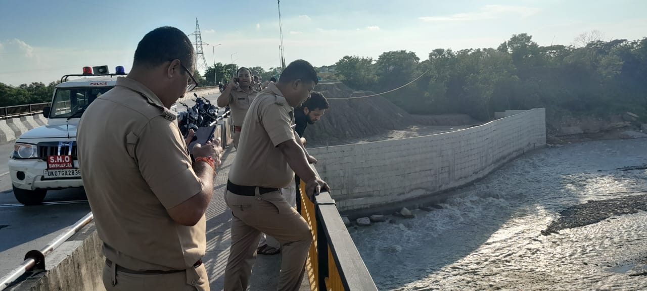 हल्द्वानी में गौला पुल से कूदे युवक को देखती पुलिस।