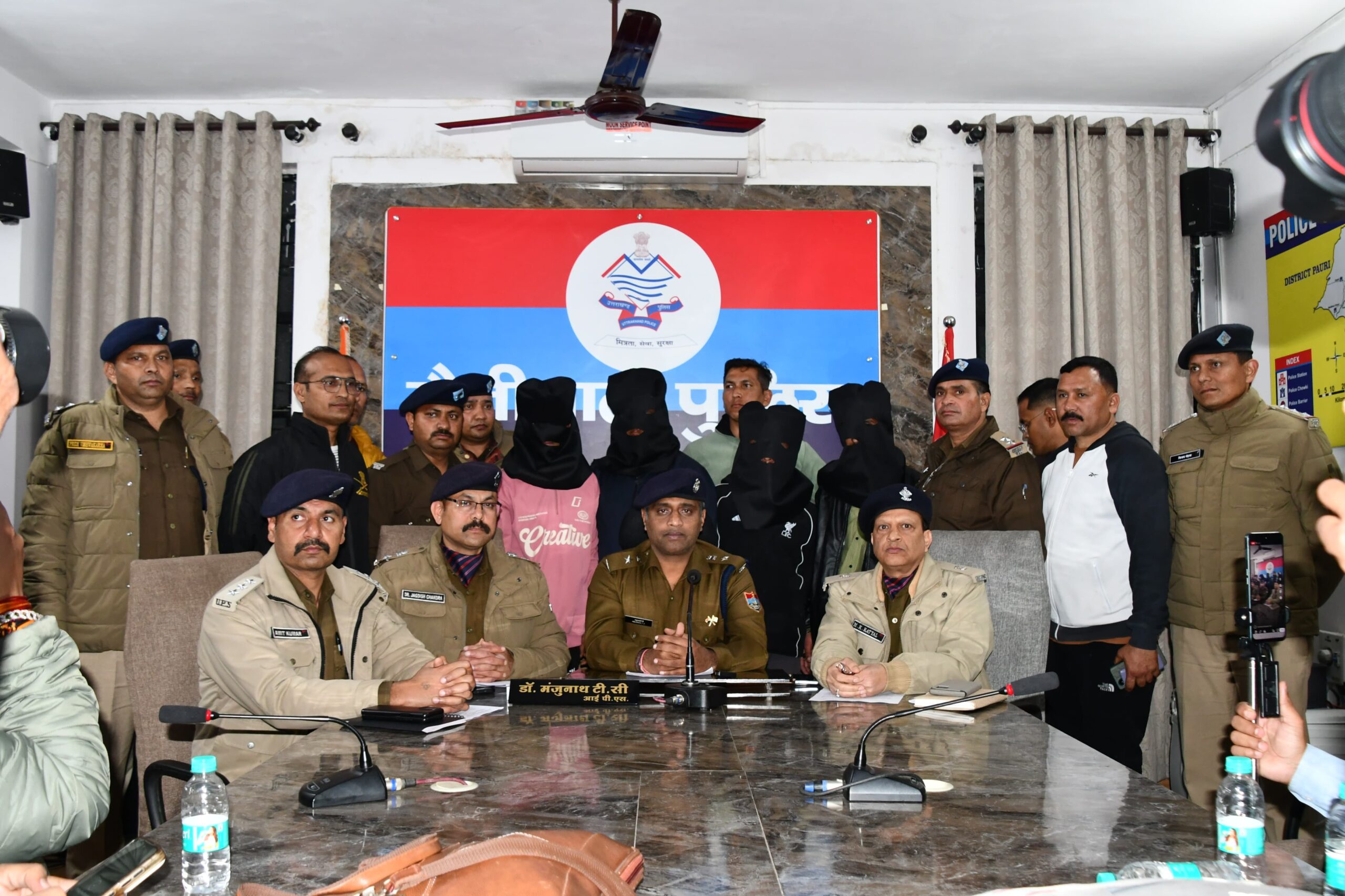 डबल मर्डर का खुलासा करते एसएसपी डॉ मंजूथान टीसी, पीछे पुलिस टीम के साथ नकाब में हत्यारे दोस्त।