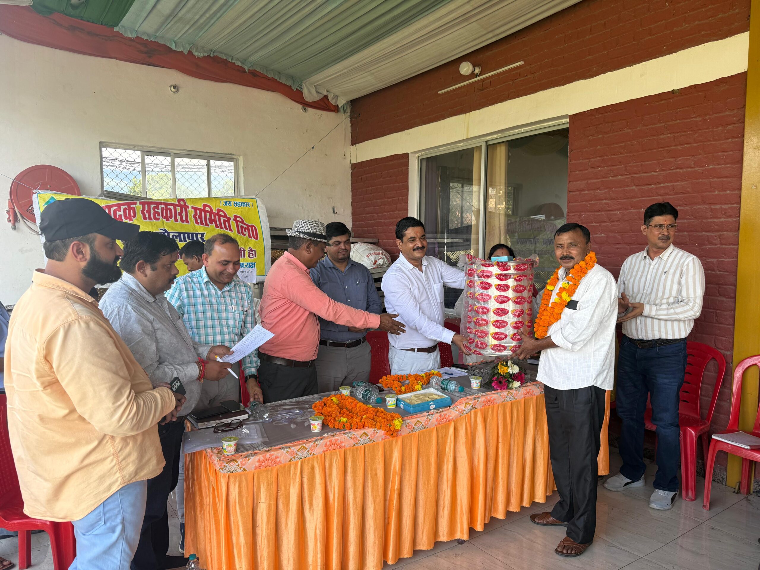 दुग्ध उत्पादकों को उपहार देते दुग्ध संघ के अध्यक्ष मुकेश बोरा व अन्य।